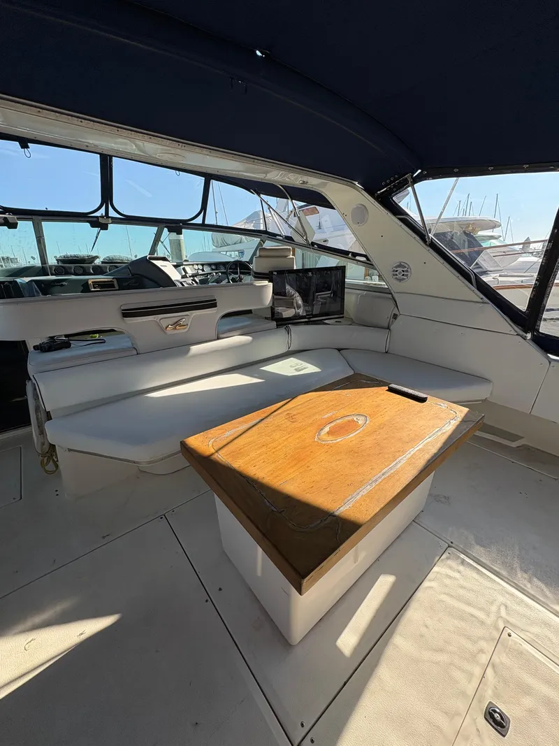 Slide: The Image of Interior of 1991 Sea Ray Sun Dancer 480 Express with seating and wooden table. - 29