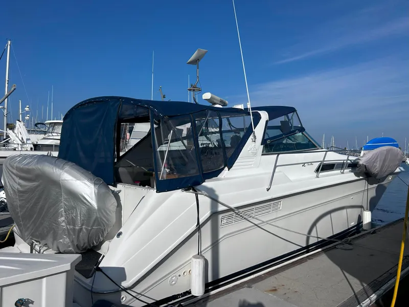Slide: The Image of 1991 Sea Ray Sun Dancer 480 Express docked at marina under clear blue sky. - 3