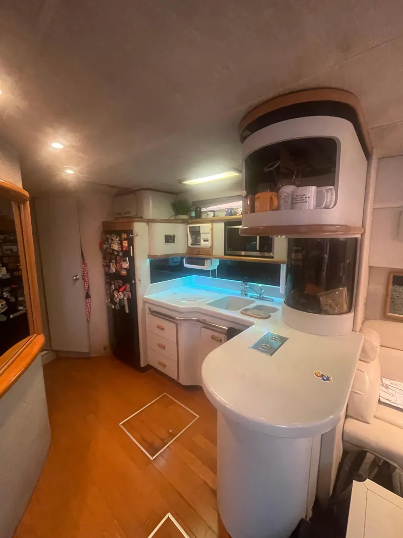 Slide: The Image of Interior of 1991 Sea Ray Sun Dancer 480 Express yacht, featuring modern kitchen and seating area. - 4