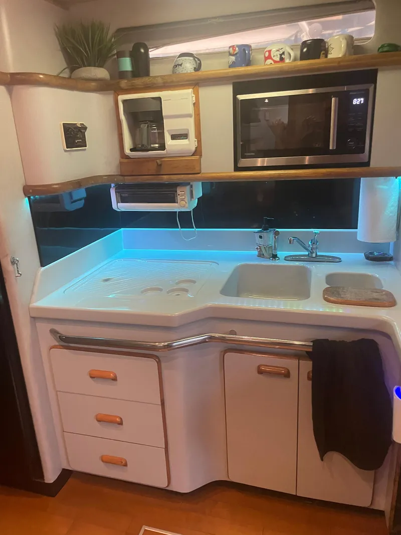 Slide: The Image of 1991 Sea Ray Sun Dancer 480 Express yacht kitchen with modern appliances and ambient lighting. - 6