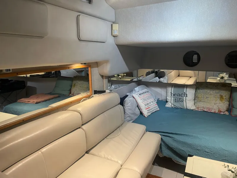 Slide: The Image of Interior of 1991 Sea Ray Sun Dancer 480 Express with cozy seating and bed. - 8