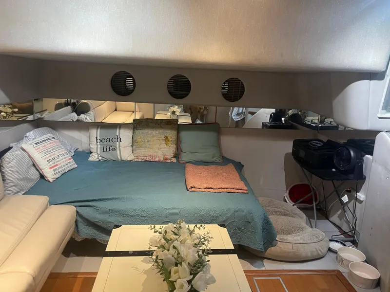 Slide: The Image of Interior of 1991 Sea Ray Sun Dancer 480 Express with cozy seating and decorative pillows. - 9