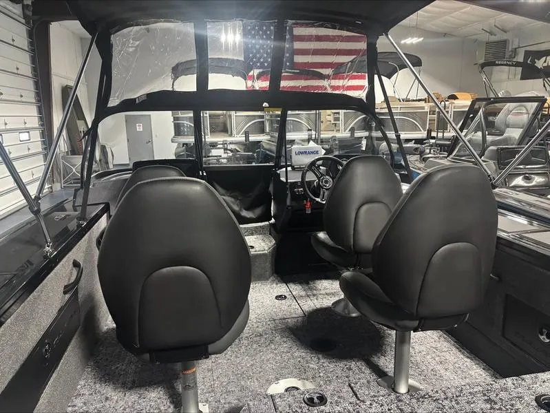 Slide: The Image of 2025 Tracker Targa™ V-18 WT boat interior with black seats and American flag. - 10