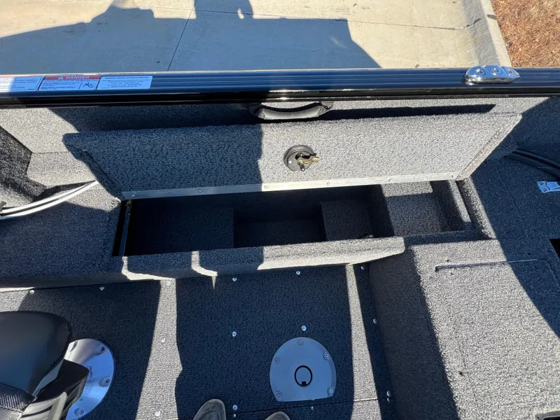 Slide: The Image of 2025 Lund 1650 Rebel XL SS boat interior with storage compartment open. - 10