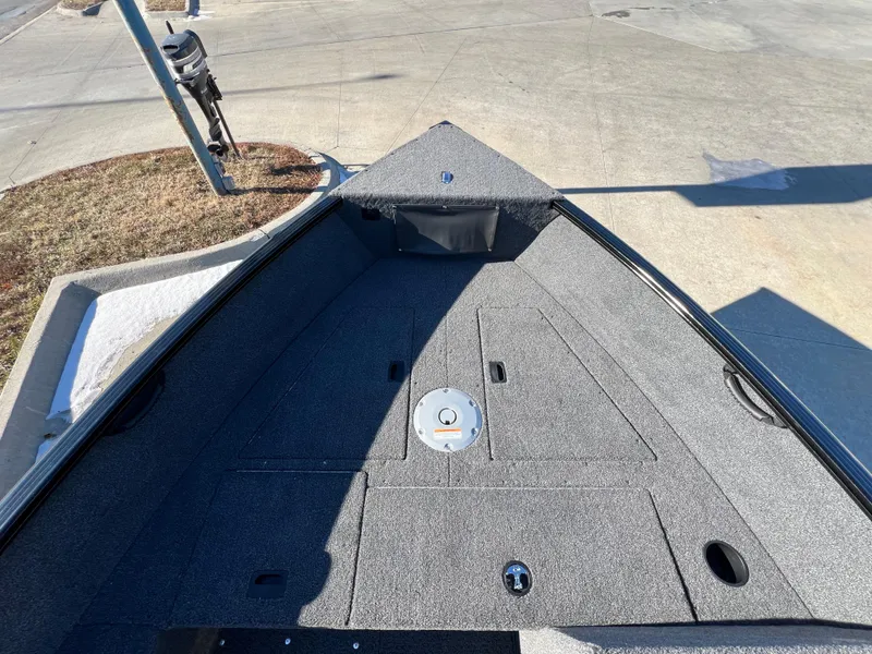 Slide: The Image of 2025 Lund 1650 Rebel XL SS boat interior with gray carpeted deck. - 12