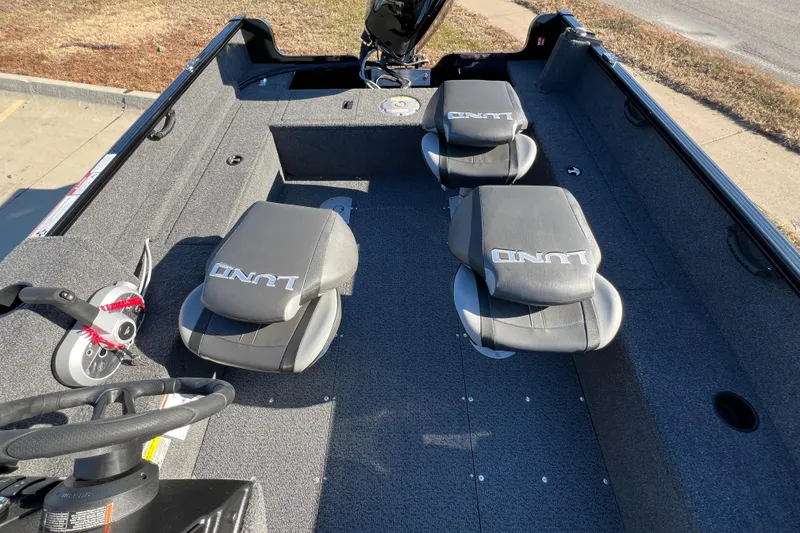 Slide: The Image of 2025 Lund 1650 Rebel XL SS boat interior with three seats and steering wheel. - 15