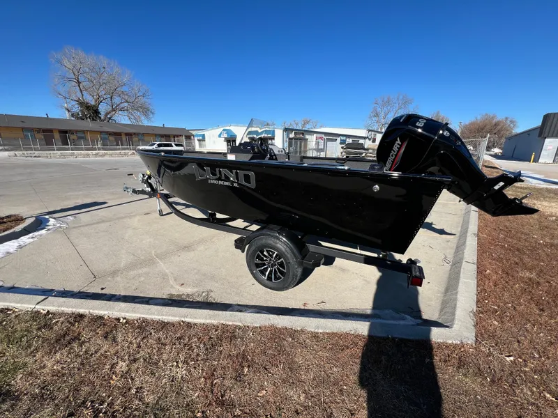 Slide: The Image of 2025 Lund 1650 Rebel XL SS boat on trailer, parked outdoors. - 2