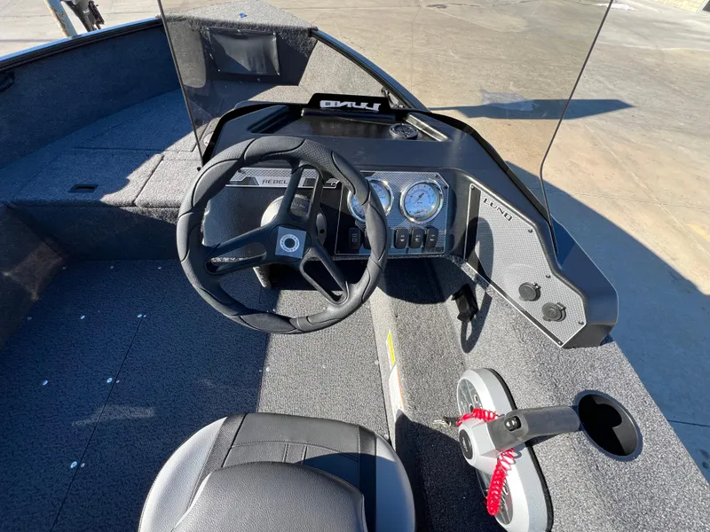 Slide: The Image of 2025 Lund 1650 Rebel XL SS boat interior with steering wheel and dashboard controls. - 9