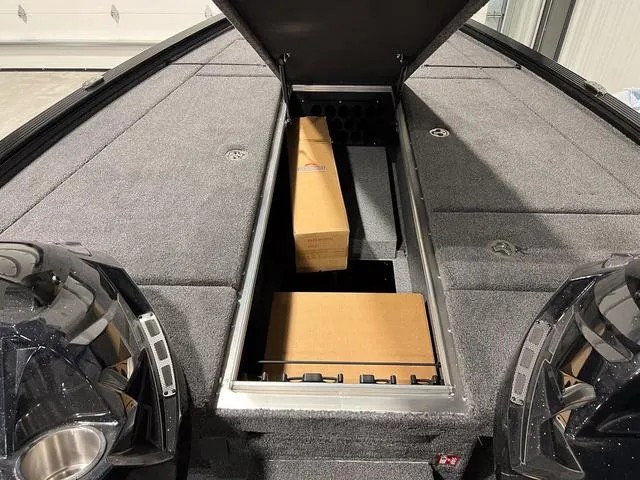 Slide: The Image of 2025 Lund 2075 Pro-V Bass XS boat with open storage compartment, showcasing spacious interior. - 24