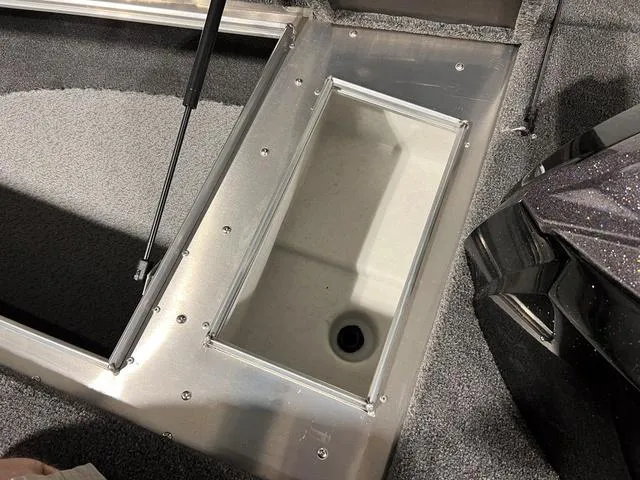 Slide: The Image of 2025 Lund 2075 Pro-V Bass XS boat storage compartment with carpeted interior and hydraulic lift. - 26