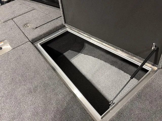 Slide: The Image of Storage compartment in 2025 Lund 2075 Pro-V Bass XS boat, featuring carpeted interior. - 27