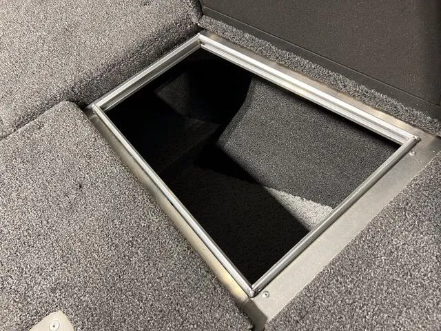 Slide: The Image of Storage compartment in 2025 Lund 2075 Pro-V Bass XS boat, featuring carpeted interior. - 28