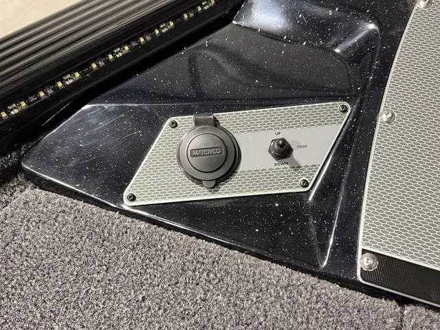 Slide: The Image of 2025 Lund 2075 Pro-V Bass XS boat control panel with trim switch and textured surface. - 30