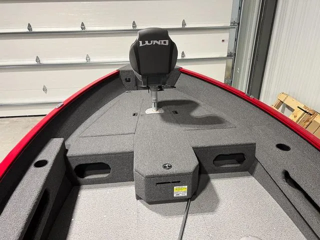 Slide: The Image of 2024 Lund 1775 Pro Guide Tiller boat interior with gray seating and storage compartments. - 11