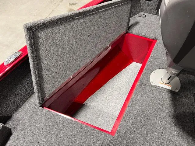 Slide: The Image of 2024 Lund 1775 Pro Guide Tiller boat storage compartment, open and carpeted. - 13