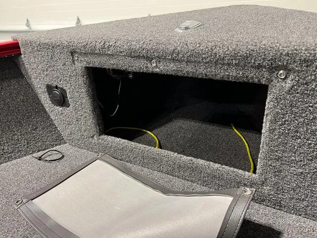 Slide: The Image of 2024 Lund 1775 Pro Guide Tiller boat storage compartment with carpeted interior. - 15