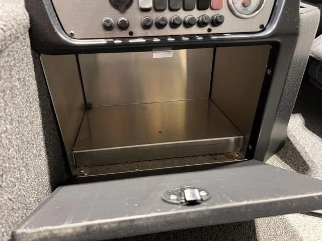 Slide: The Image of 2024 Lund 1775 Pro Guide Tiller storage compartment with control panel. - 9