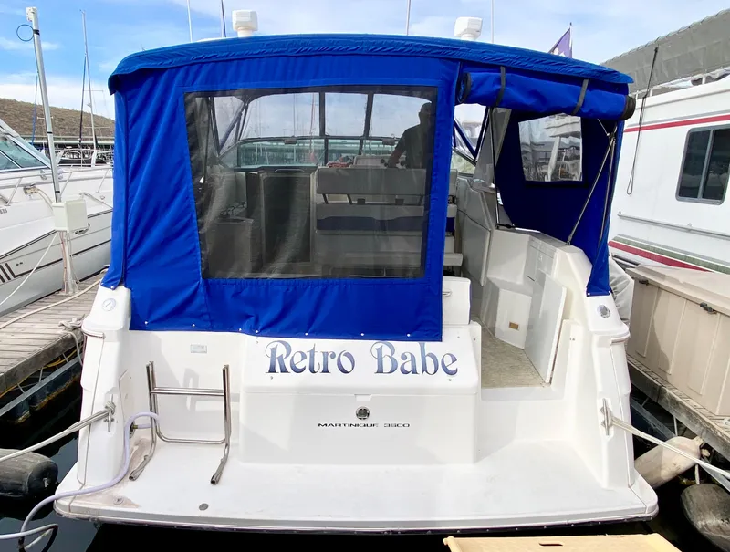 Slide: The Image of 1995 Wellcraft 3600 Martinique boat with blue canopy, named "Retro Babe," docked at marina. - 2
