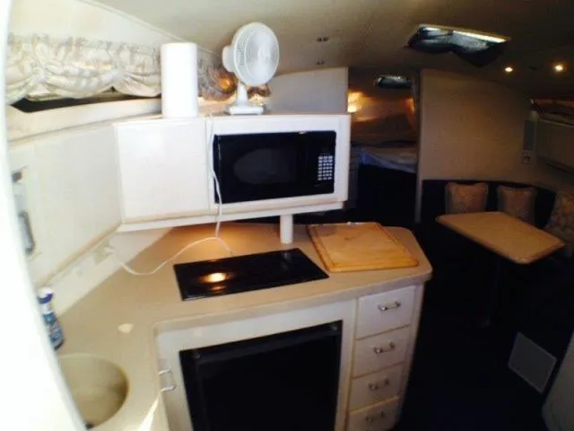 Slide: The Image of 1995 Wellcraft 3600 Martinique yacht interior with kitchen, microwave, and dining area. - 24
