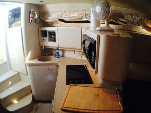 Slide: The Image of Wellcraft 3600 Martinique 1995 boat kitchen with microwave, stove, and sink. - 25