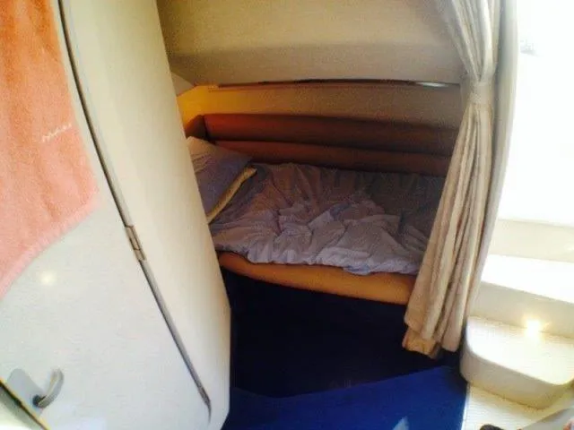 Slide: The Image of Cozy cabin interior of 1995 Wellcraft 3600 Martinique boat with bed and curtain. - 28
