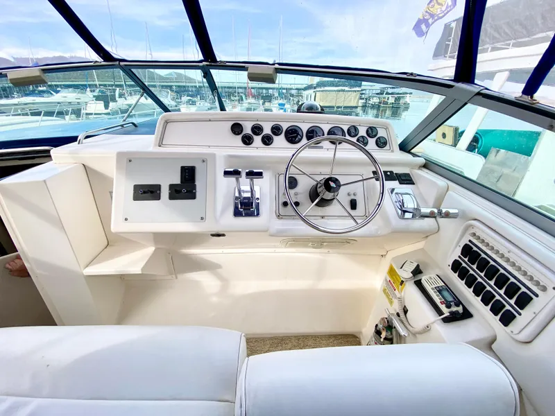 Slide: The Image of 1995 Wellcraft 3600 Martinique helm with steering wheel and control panel, docked at marina. - 3