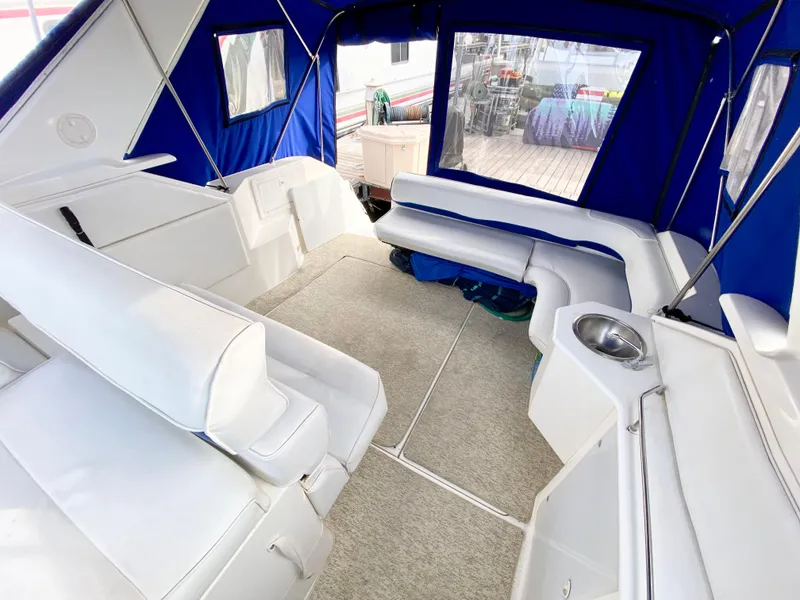 Slide: The Image of 1995 Wellcraft 3600 Martinique boat interior with white seating and blue canopy. - 6