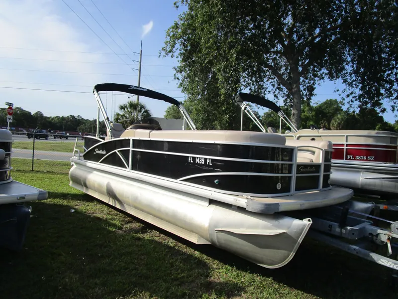 Slide: The Image of 2013 Sweetwater Premium SW 220 WB pontoon boat parked on grass under a tree. - 5