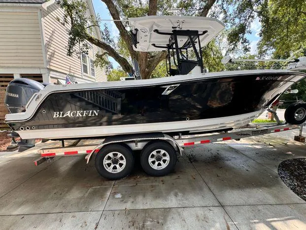 Slide: The Image of 2021 Blackfin 252 CC boat on trailer, parked in driveway. - 0