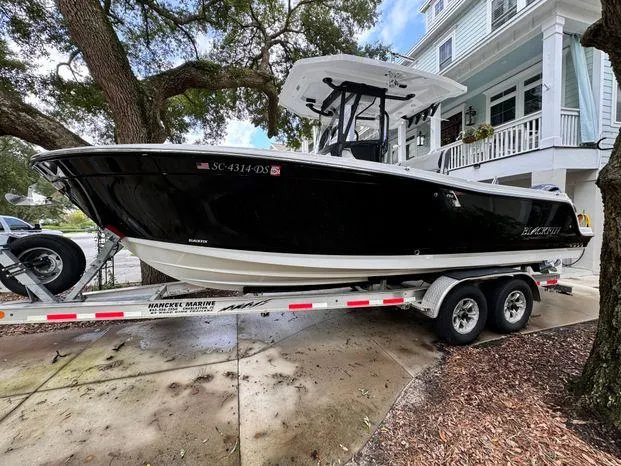 Slide: The Image of 2021 Blackfin 252 CC boat on trailer, parked near a house. - 12