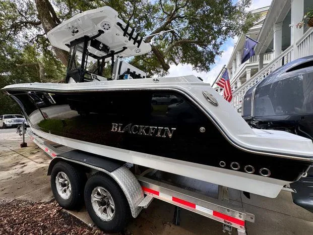Slide: The Image of 2021 Blackfin 252 CC boat on trailer, parked outdoors. - 14