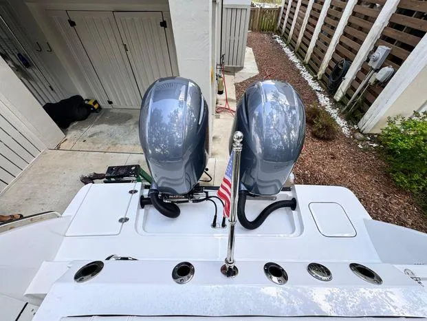 Slide: The Image of 2021 Blackfin 252 CC boat with dual engines and American flag. - 17