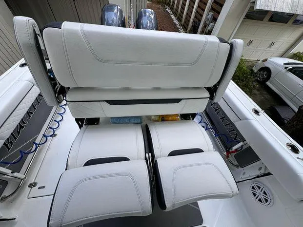 Slide: The Image of 2021 Blackfin 252 CC boat interior with white seating and dual engines. - 20