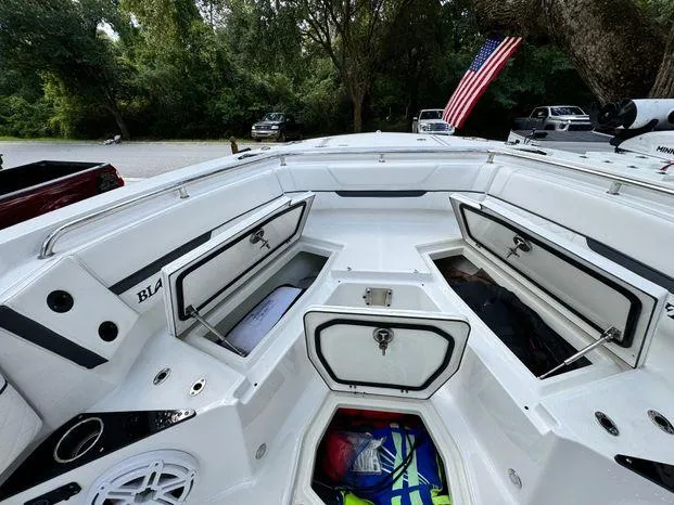 Slide: The Image of 2021 Blackfin 252 CC boat interior with open storage compartments and American flag. - 29