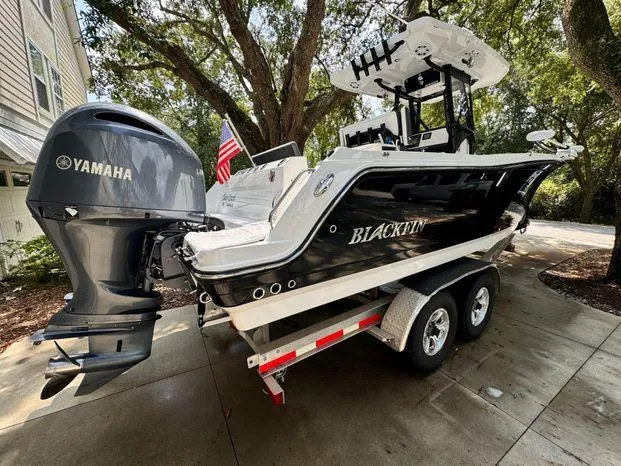 Slide: The Image of 2021 Blackfin 252 CC boat on trailer with Yamaha engine, parked outdoors. - 3