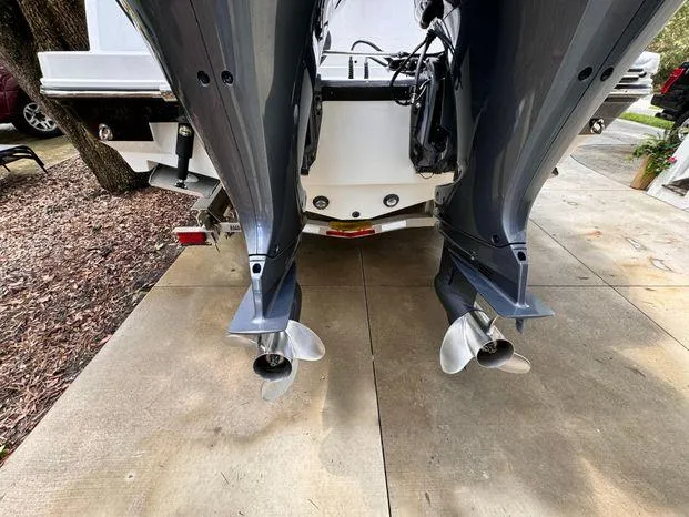 Slide: The Image of 2021 Blackfin 252 CC boat with dual outboard motors on a concrete driveway. - 6