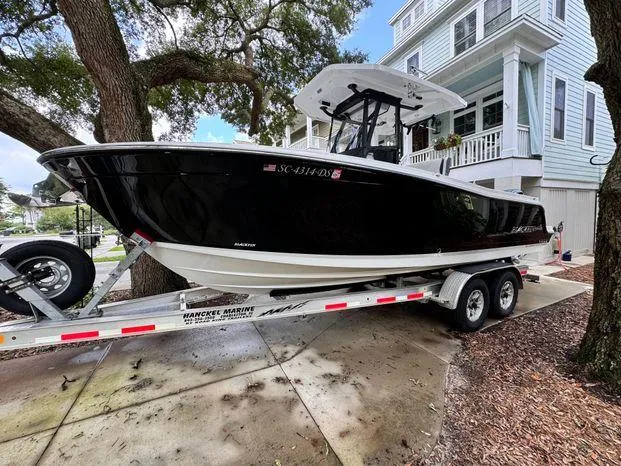 Slide: The Image of 2021 Blackfin 252 CC boat on trailer, parked near a house. - 7