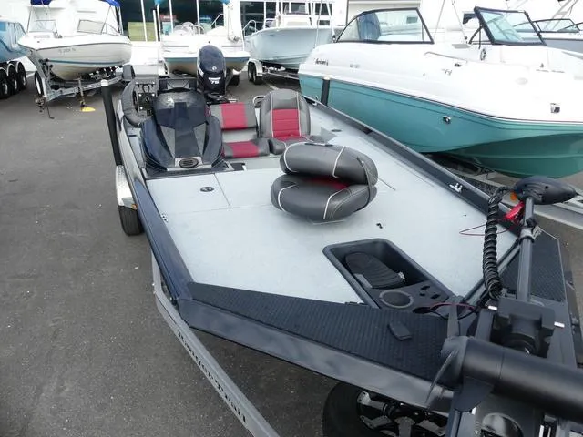 Slide: The Image of 2018 Ranger RT178 boat with red and black seating, docked among other boats. - 5