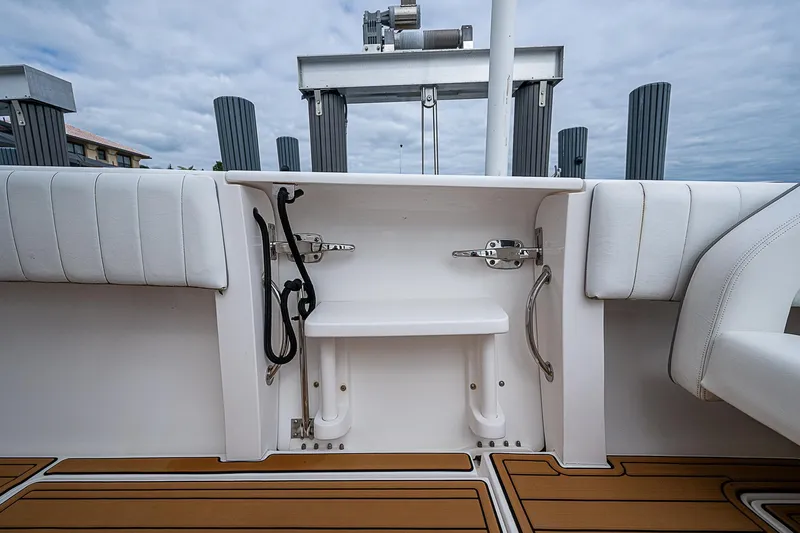 Slide: The Image of 2014 Intrepid 327 Center Console boat interior with white seating and wooden deck. - 15