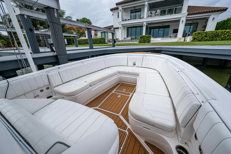 Slide: The Image of 2014 Intrepid 327 Center Console boat with spacious white seating and wooden deck. - 16