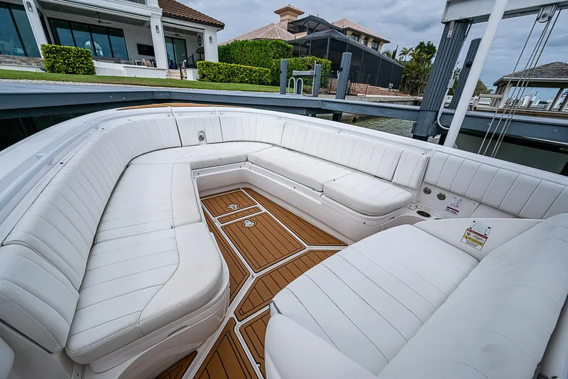 Slide: The Image of 2014 Intrepid 327 Center Console with spacious white seating and teak flooring. - 17