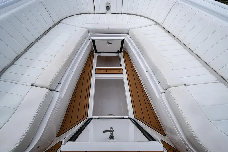 Slide: The Image of 2014 Intrepid 327 Center Console boat interior with white seating and wood accents. - 19