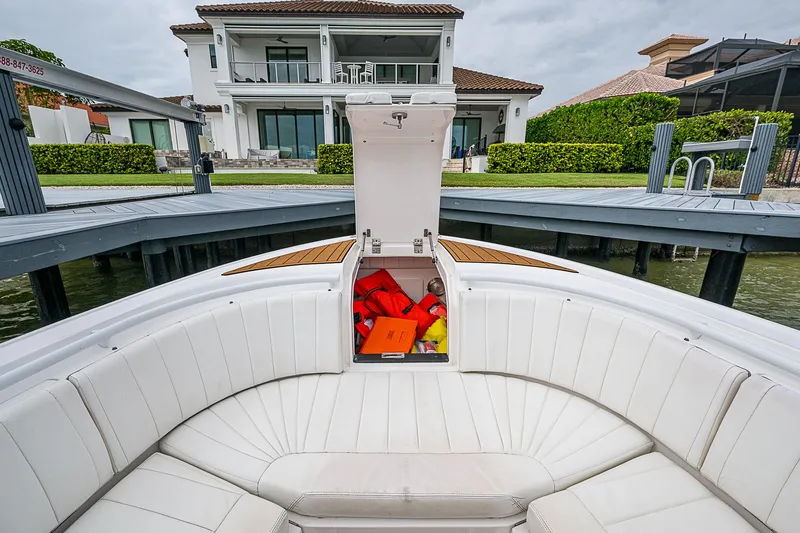 Slide: The Image of 2014 Intrepid 327 Center Console boat with open storage, docked near waterfront home. - 20
