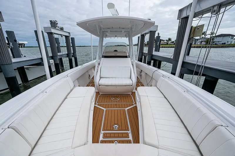 Slide: The Image of 2014 Intrepid 327 Center Console boat with white seating and wooden deck. - 21