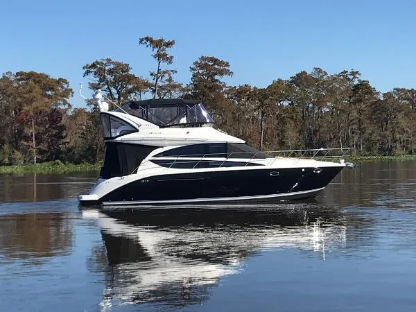 Slide: The Image of 2016 Meridian 391 Sedan yacht cruising on a calm lake with trees in the background. - 0