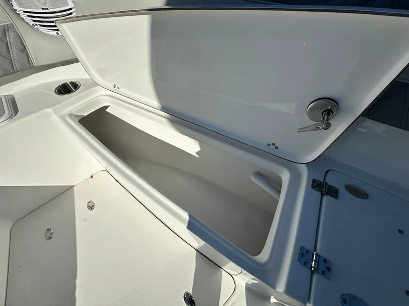 Slide: The Image of 2025 Sea Pro 322 Offshore boat storage compartment with open lid and key lock. - 12