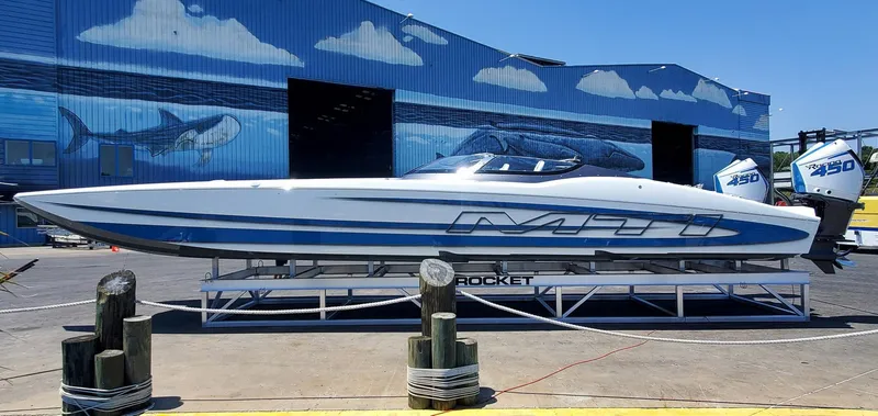Slide: The Image of 2022 MTI 390X speedboat on display at a marina with ocean-themed murals. - 13