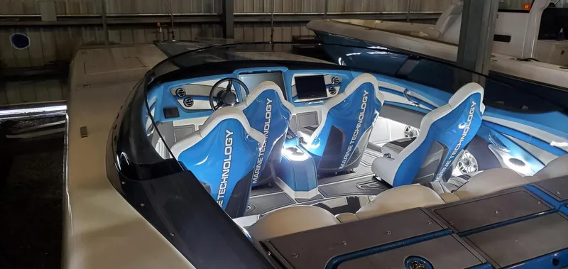 Slide: The Image of 2022 MTI 390X boat interior with blue and white seats, modern dashboard, and steering wheel. - 16