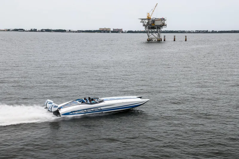 Slide: The Image of MTI 390X 2022 speedboat racing on open water near an offshore platform. - 3