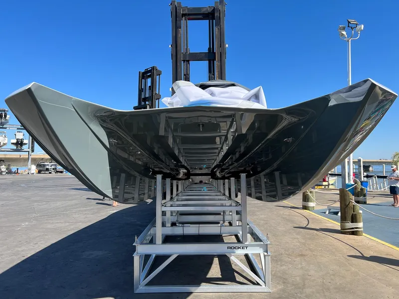 Slide: The Image of 2022 MTI 390X boat on a lift, viewed from below, clear sky background. - 6